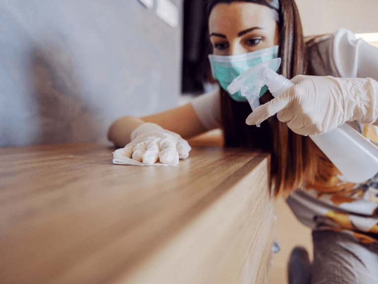 Une dame fait du nettoyage dans sa maison pour se débarrasser des germes et des bactéries