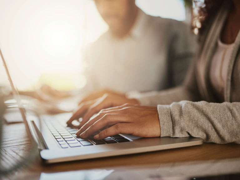 Frau, die ihre administrativen Aufgaben von einem Computer aus erledigt