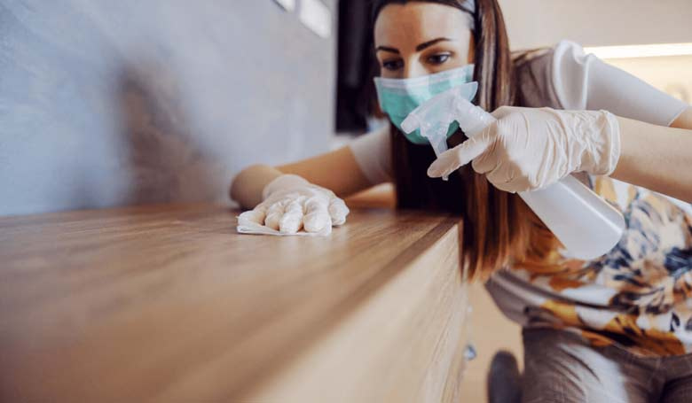 Une dame fait du nettoyage dans sa maison pour se débarrasser des germes et des bactéries