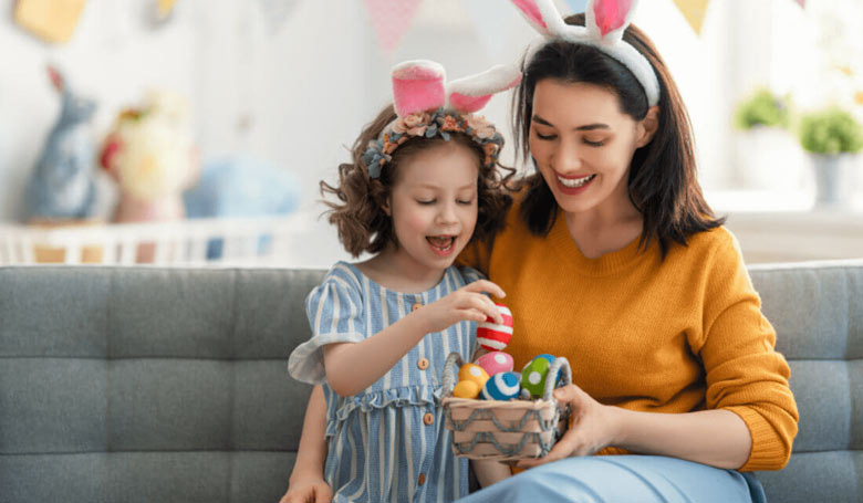 Eine Mutter und ihr Kind mit Ostereiern