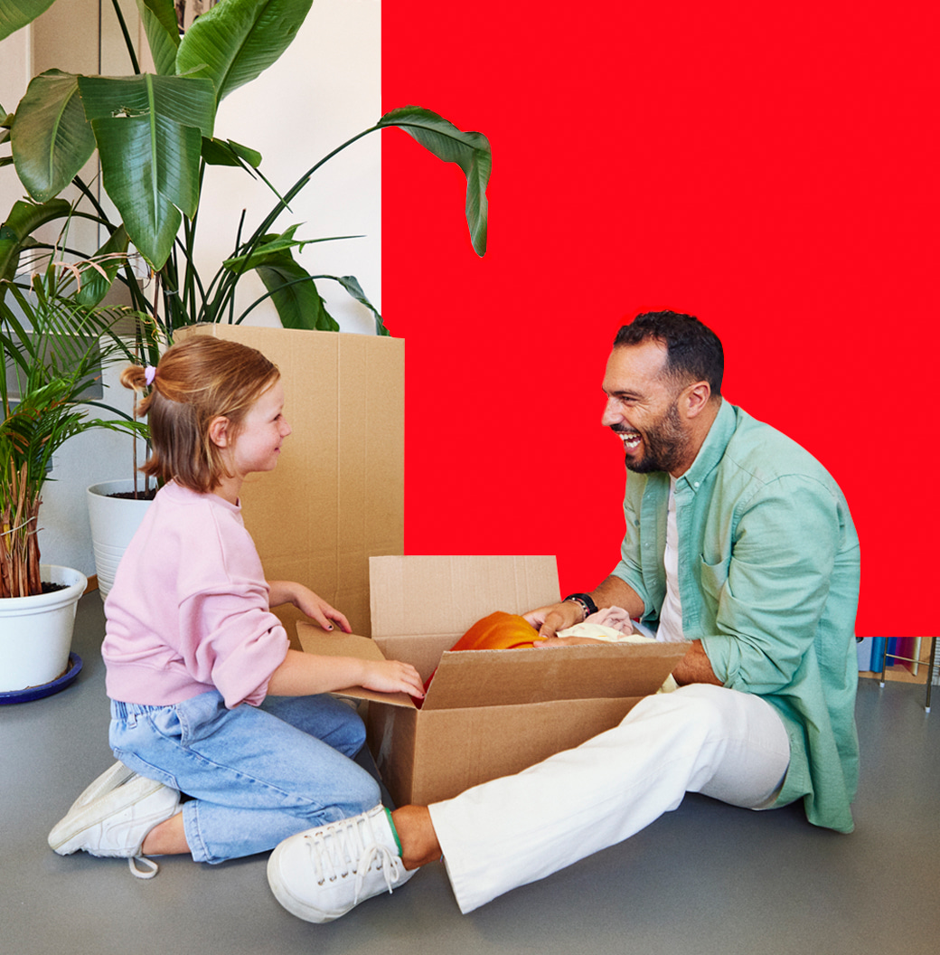 Un père et sa fille qui déballe un carton de déménagement