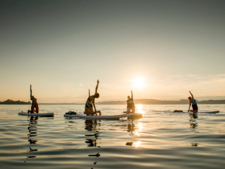 Des personnes faisant du yoga sur le lac de Morat à Fribourg