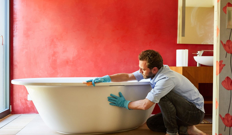 Un homme nettoyant sa baignoire