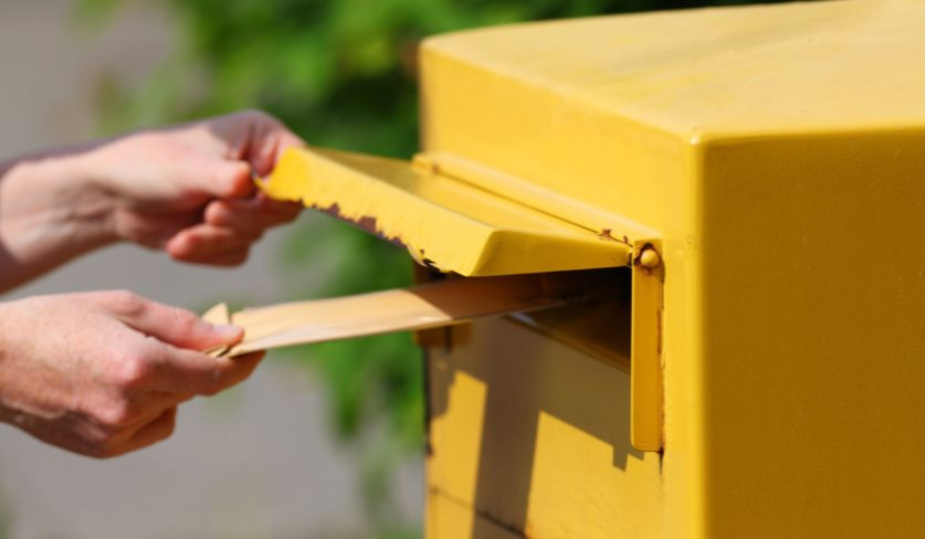 Persona che mette una lettera di preavviso in una cassetta delle lettere
