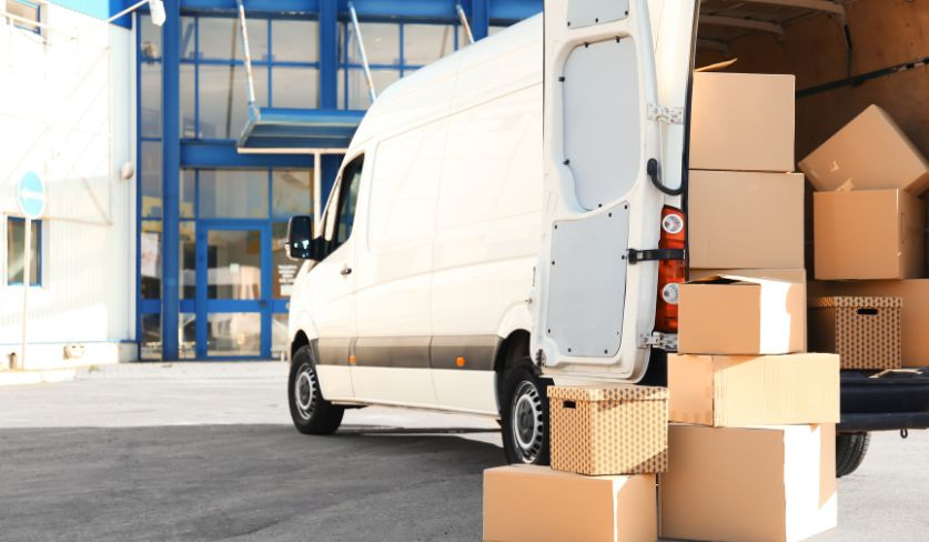 Un camion de déménagement qui a plein de carton à l'arrière