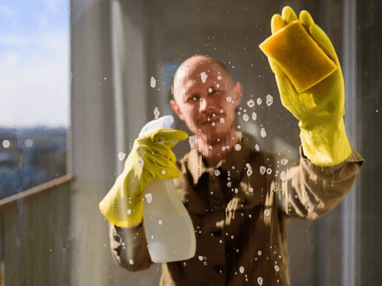Uomo che pulisce una finestra