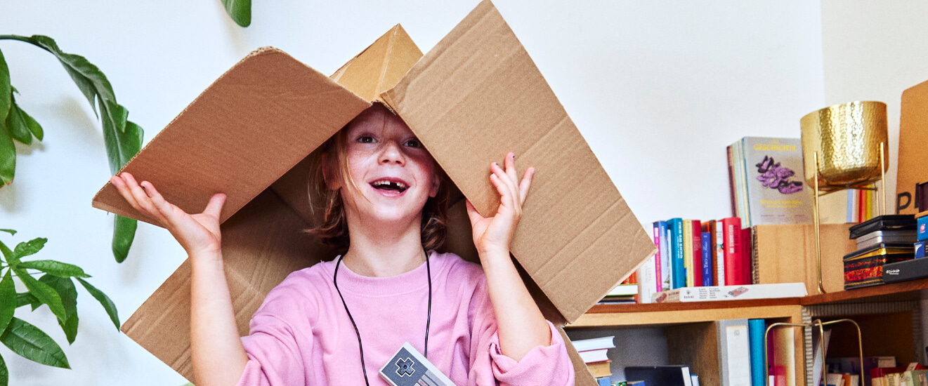 Junges Mädchen mit einem Karton auf dem Kopf
