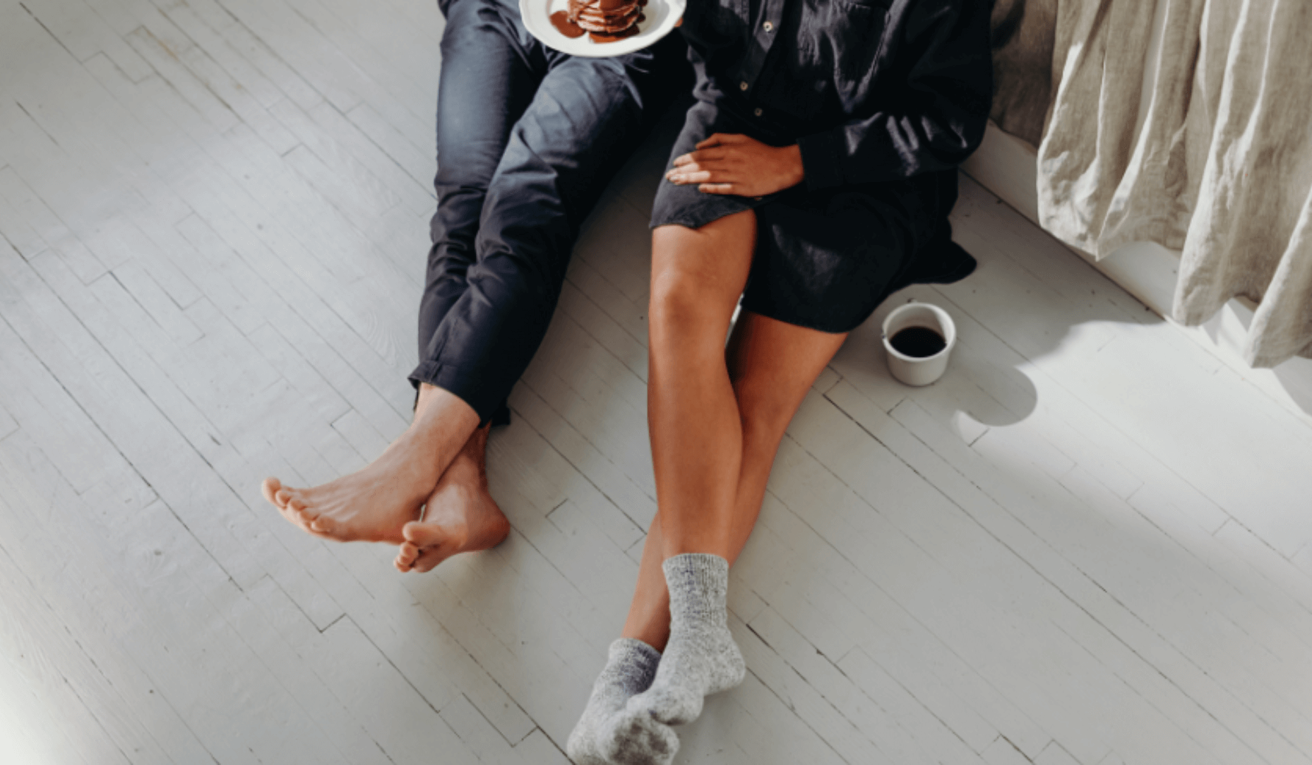 Couple en location assis par terre en train de boire un café