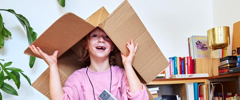 Une jeune fille jouant avec un carton sur la tête