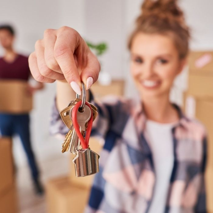 Femme qui tend un porte clé à la main