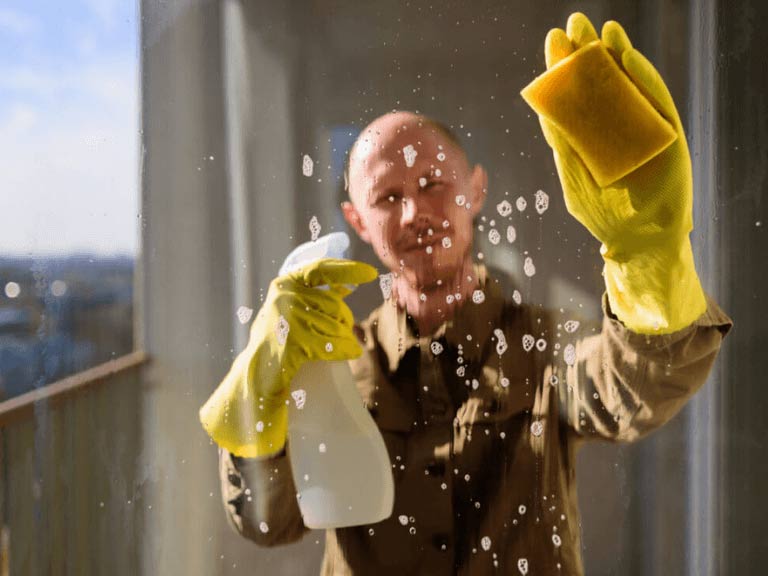 Mann putzt ein Fenster