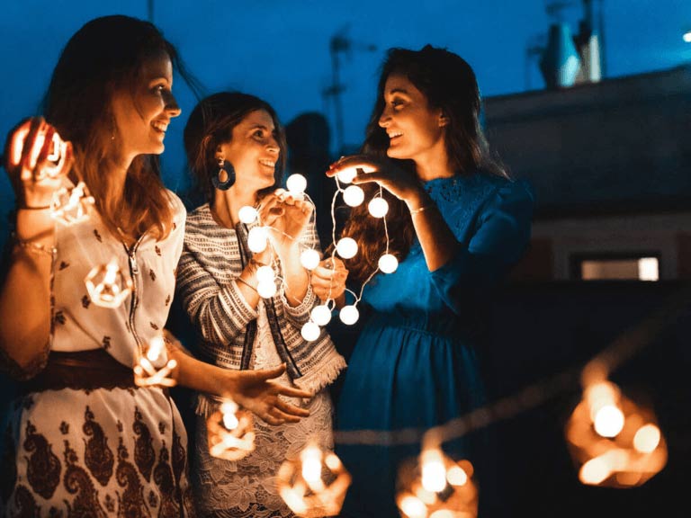 Femmes tenant des lumières tendances pour embellir leur extérieur