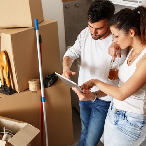 Un couple qui regarde une checkliste de déménagement en plein déménagement